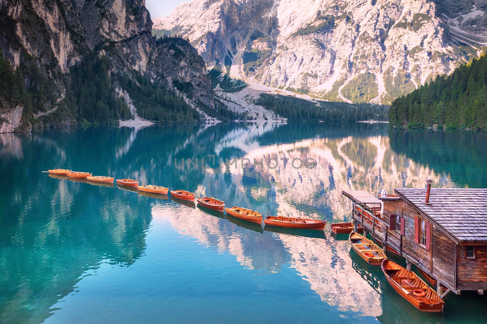 Wooden boats in a row on summer morning at Lago di Braies (also known as Pragser Wildsee) in Dolomites Mountains, Sudtirol, Italy.