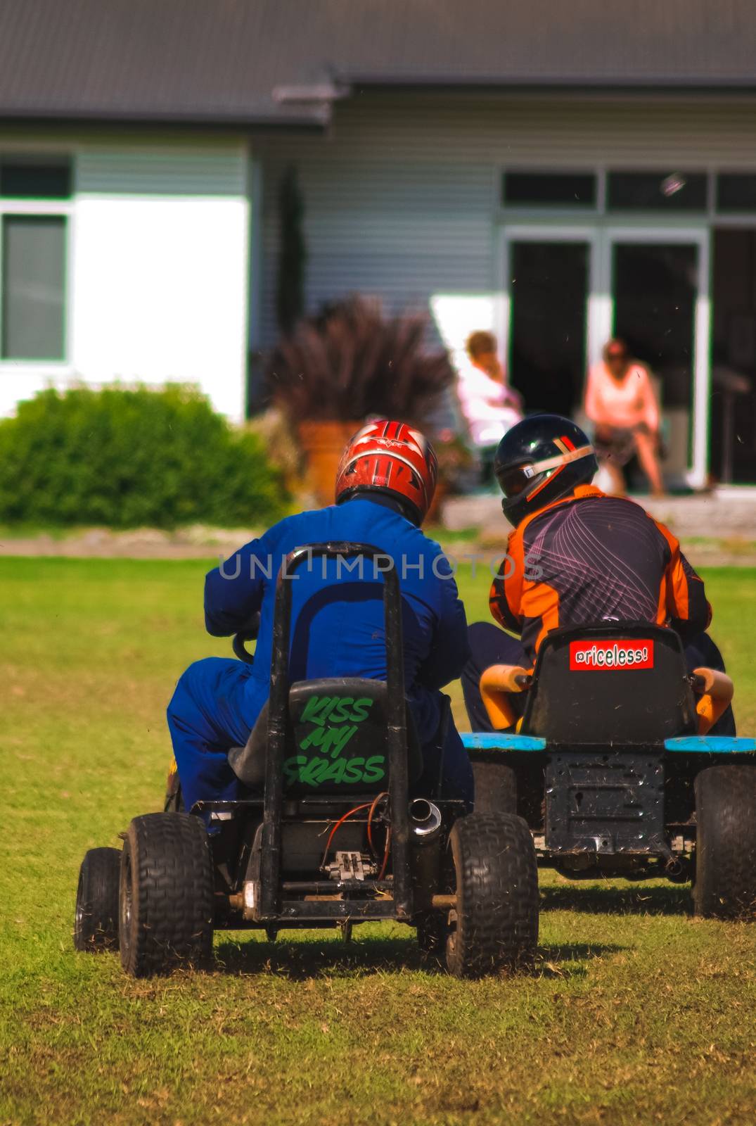A couple of drivers participating in a lawnmower race