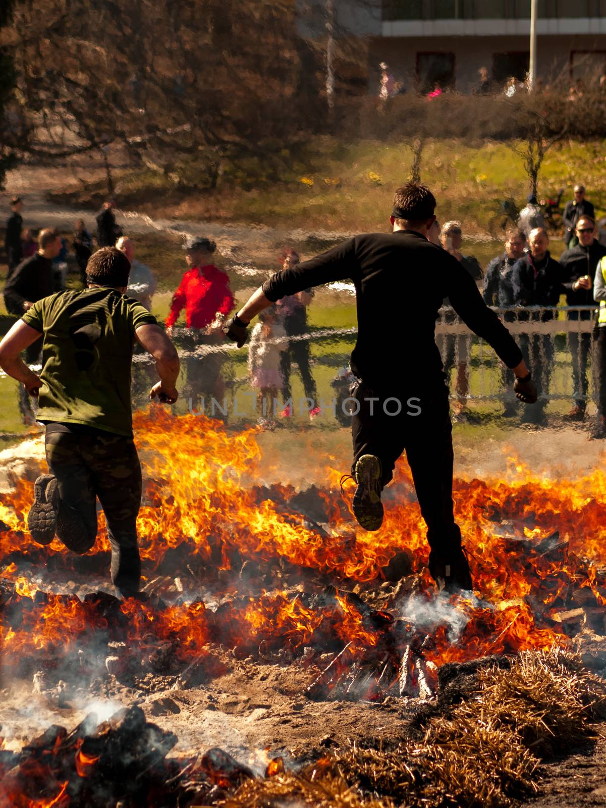 Two guys jumping over fire in a race