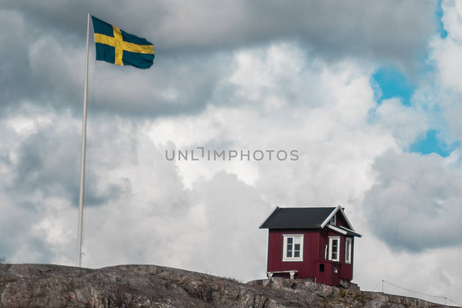 A classic red hut in Sweden next to a Swedish flag