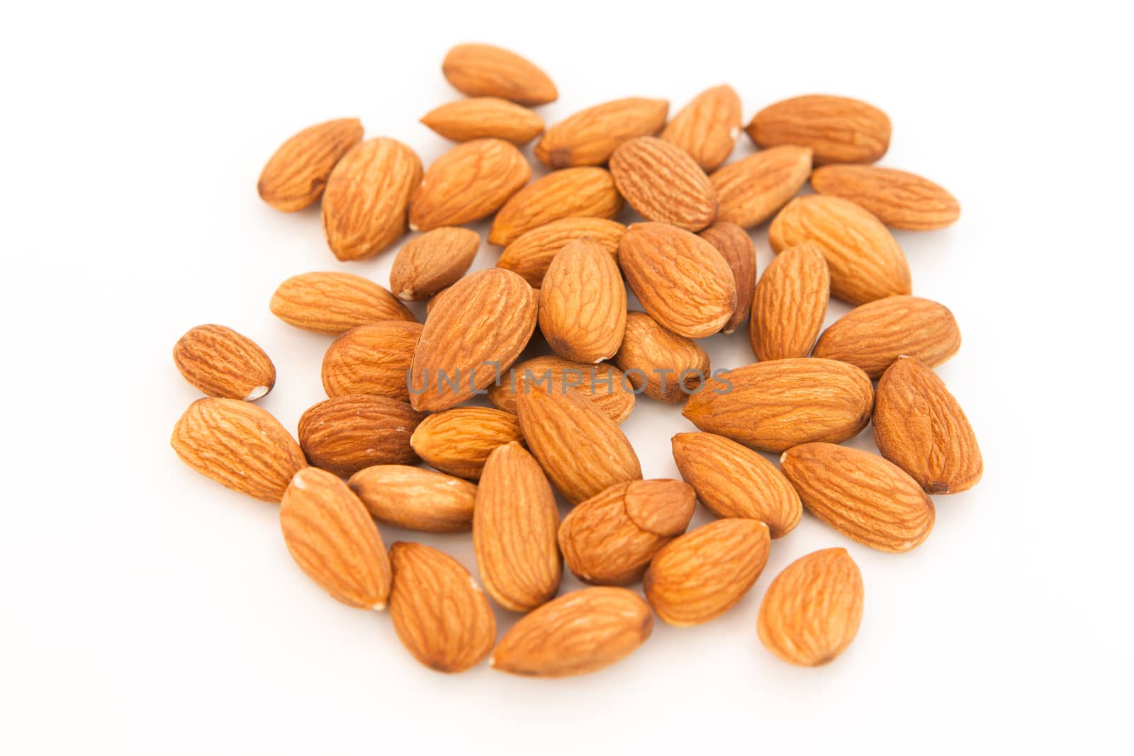 Almond superfood isolated on white background. Concept of healthy life. Close up. A handful of nuts in the center of the frame