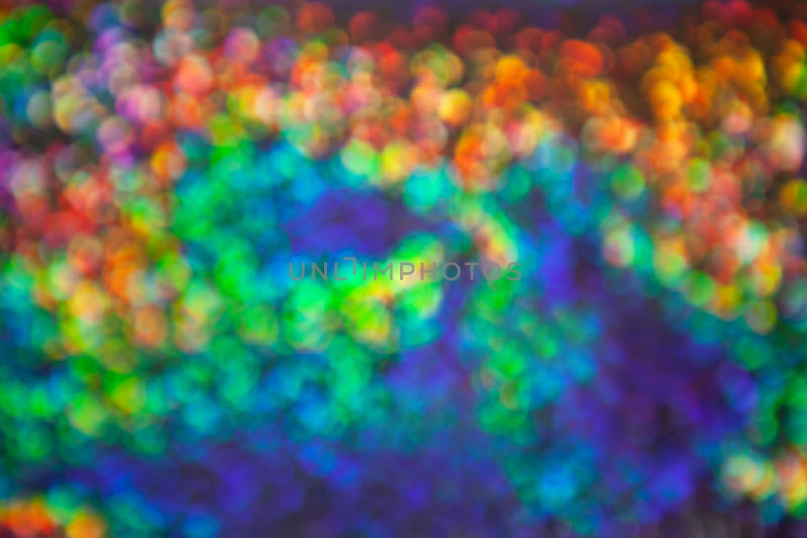 Abstract blurred background with numerous colourful bright festive bokeh. Texture with copy space for text. Celebration, holidays concept. Horizontal.