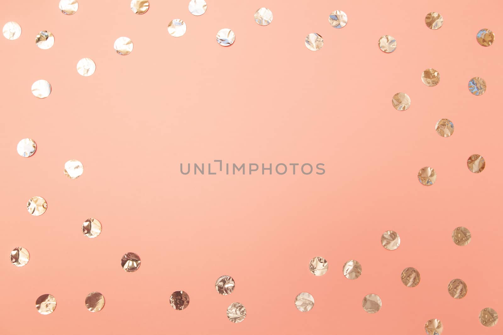 Frame of shiny silver confetti on pastel millennial pink paper background. Concept of holiday, birthday, blogging. Top view. Flat lay. Minimal style. Template for female blog. Lifestyle. Copy space.