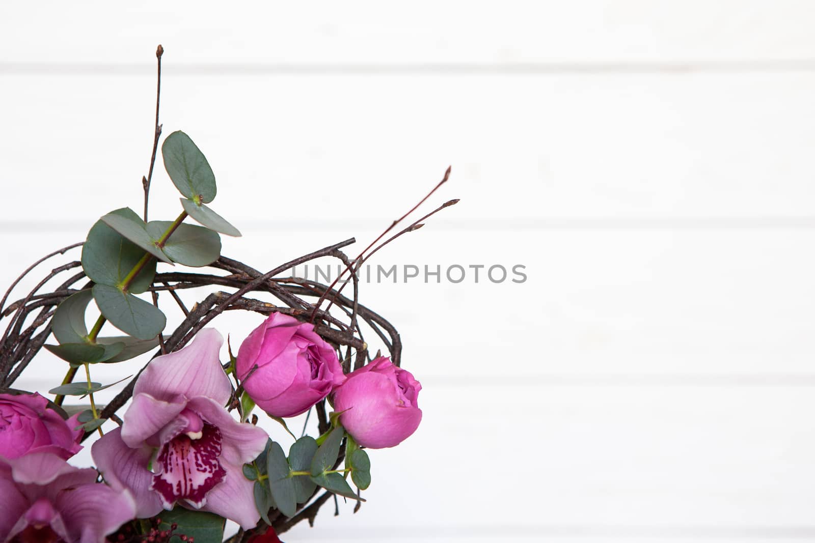 Creative flower bouquet on white wooden background. Focus on flowers, background is blurred. Mockup with copy space for greeting card, social media, flower delivery, Mother's day, Women's Day.