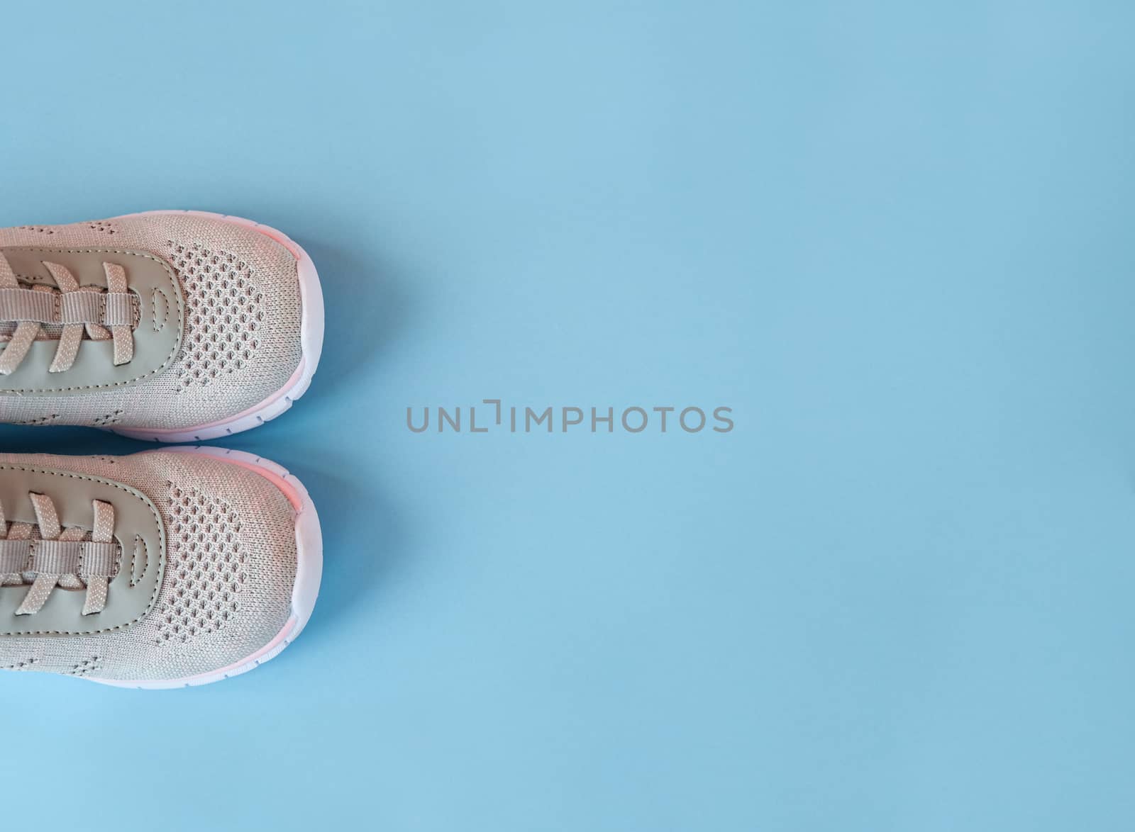 Sport, healthy lifestyle concept. New gray sneakers on pastel blue background. Copy space. Flat lay.