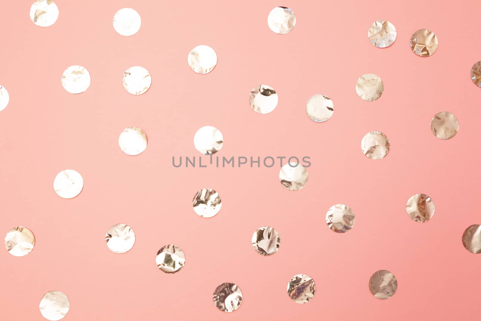Pattern of shiny silver confetti on pastel millennial pink paper background. Concept of holiday, birthday, blogging, beauty. Top view. Flat lay. Minimal style mock up. Template for blog. Copy space.