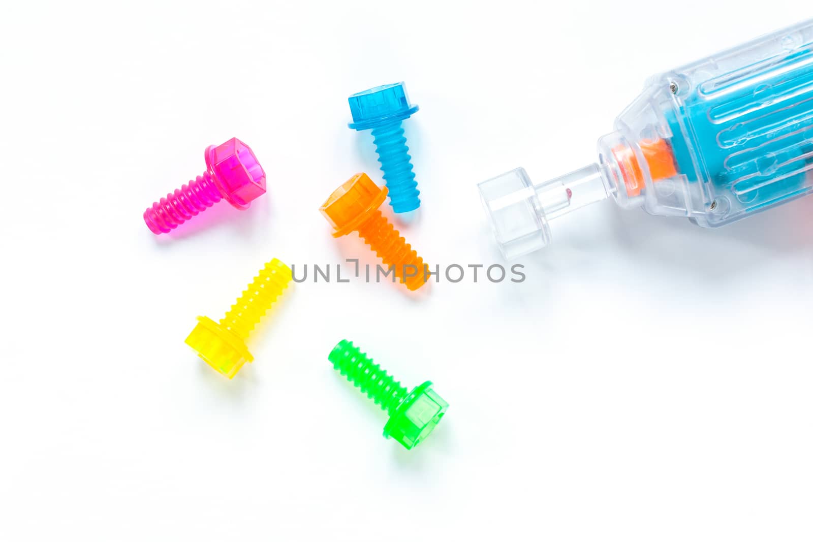 Colored neon translucent plastic toy bolts and screwdriver on white background. Concept World Dad's Day, unisex toys for early development, role-playing games. Layout for social media, toy stores