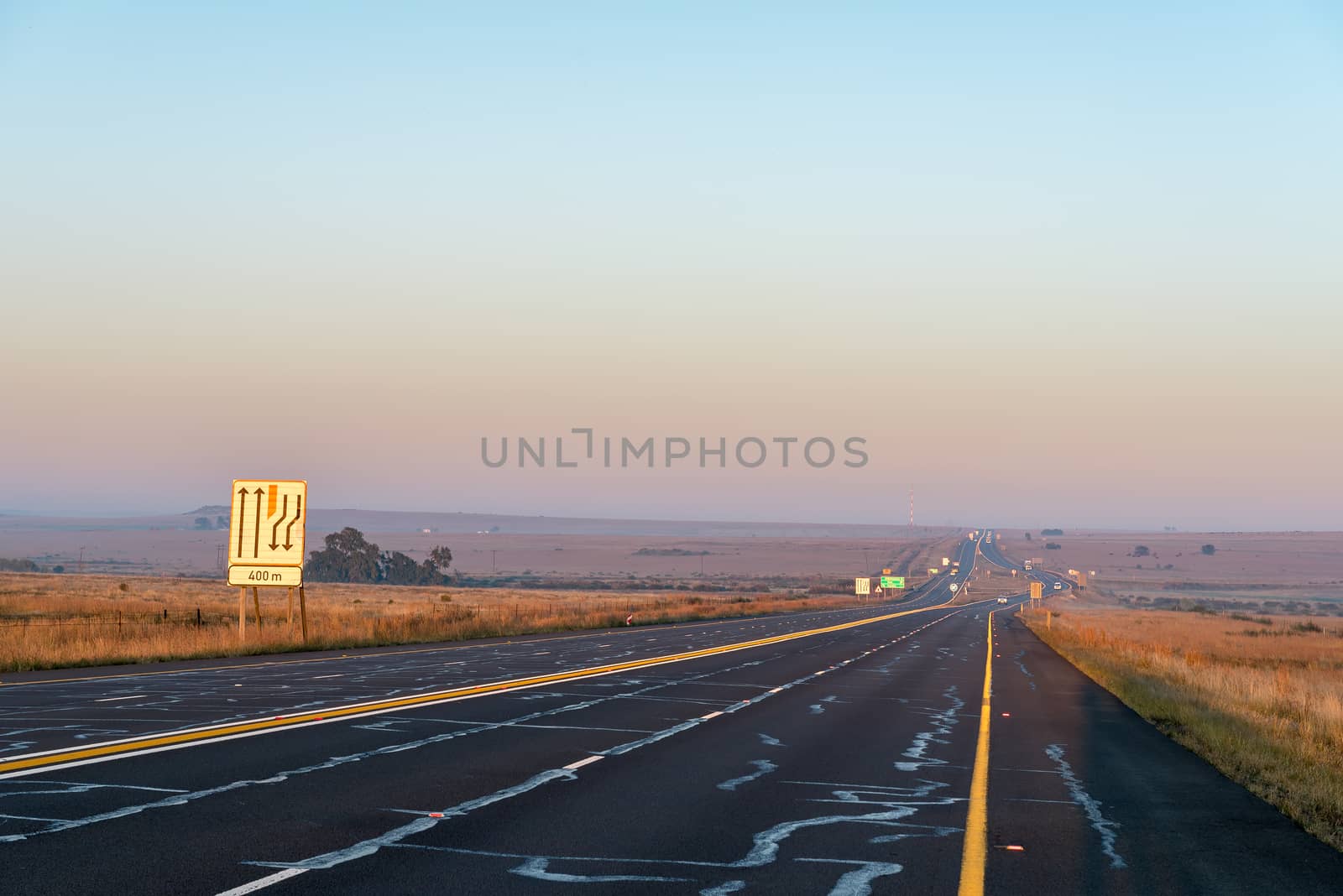 The sun is rising over road N1 at the Verkeerdevlei junction north of Bloemfontein, South Africa
