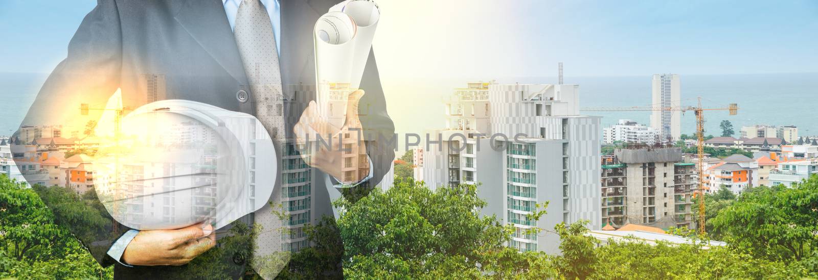 Double exposure of Engineer with safety helmet on construction industry background.