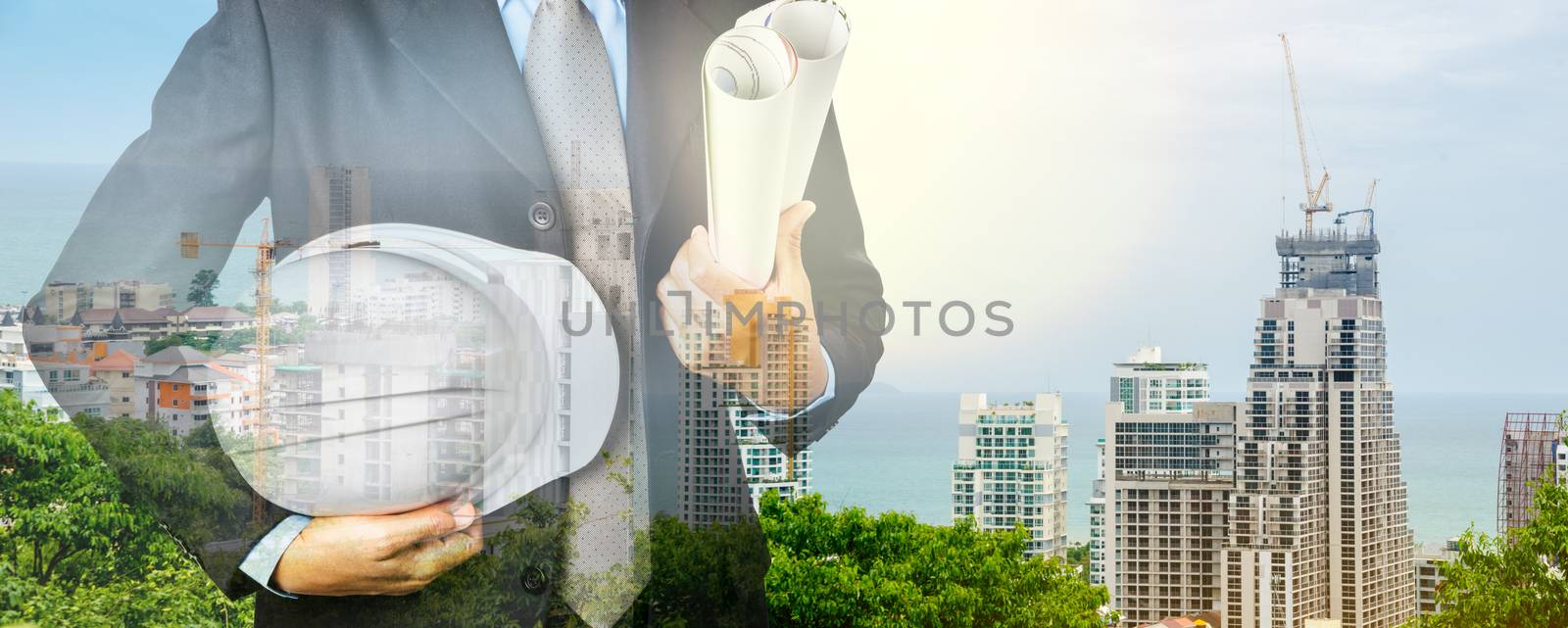 Double exposure of Engineer with safety helmet on construction industry background.