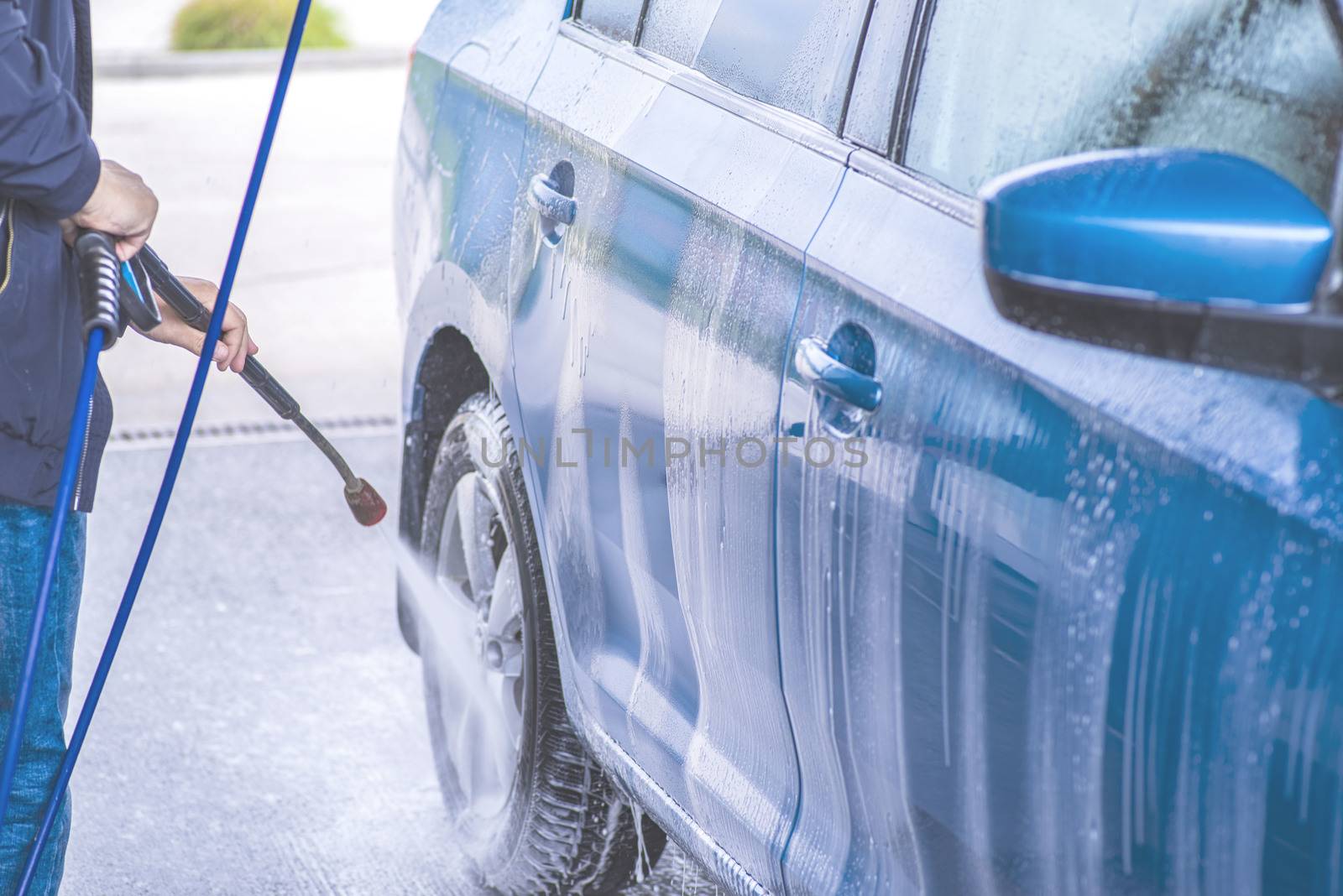 Cleaning Car Using High Pressure Water.Manual car wash with pressurized water in car wash outside.