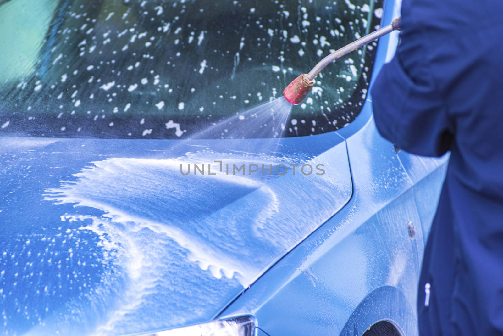 Cleaning Car Using High Pressure Water.Manual car wash with pressurized water in car wash outside.
