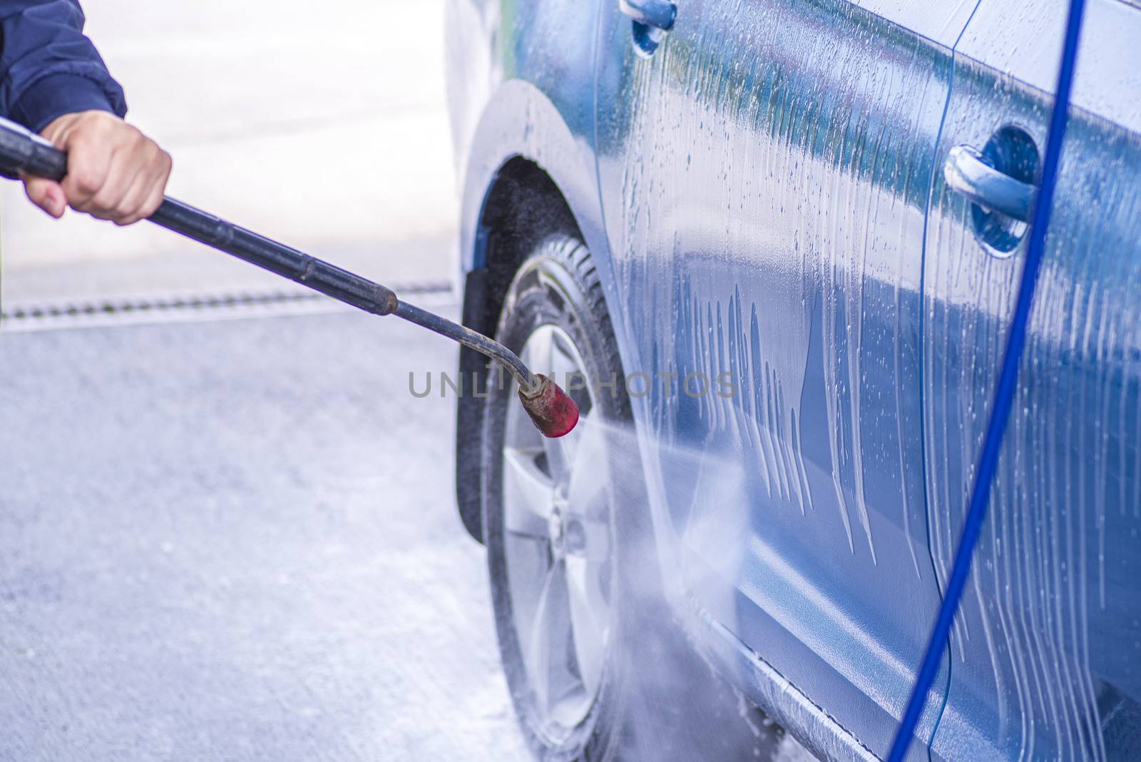 Cleaning Car Using High Pressure Water.Manual car wash with pressurized water in car wash outside.