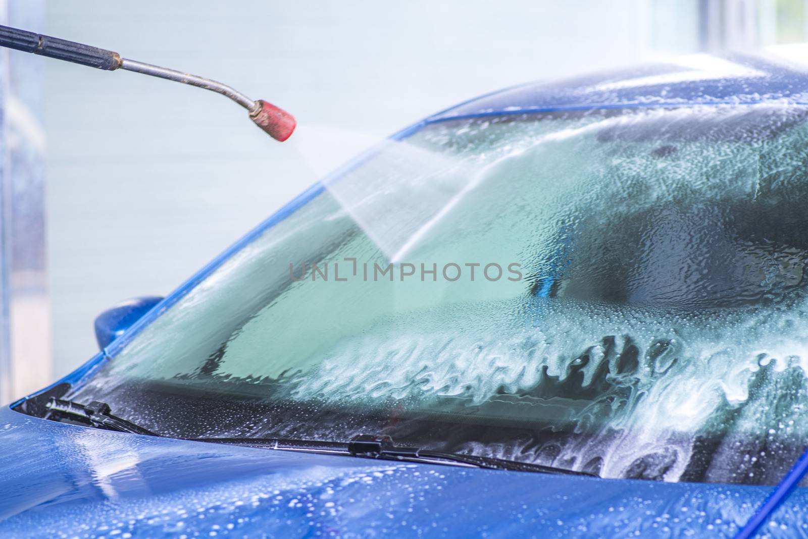 Cleaning Car Using High Pressure Water.Manual car wash with pressurized water in car wash outside.