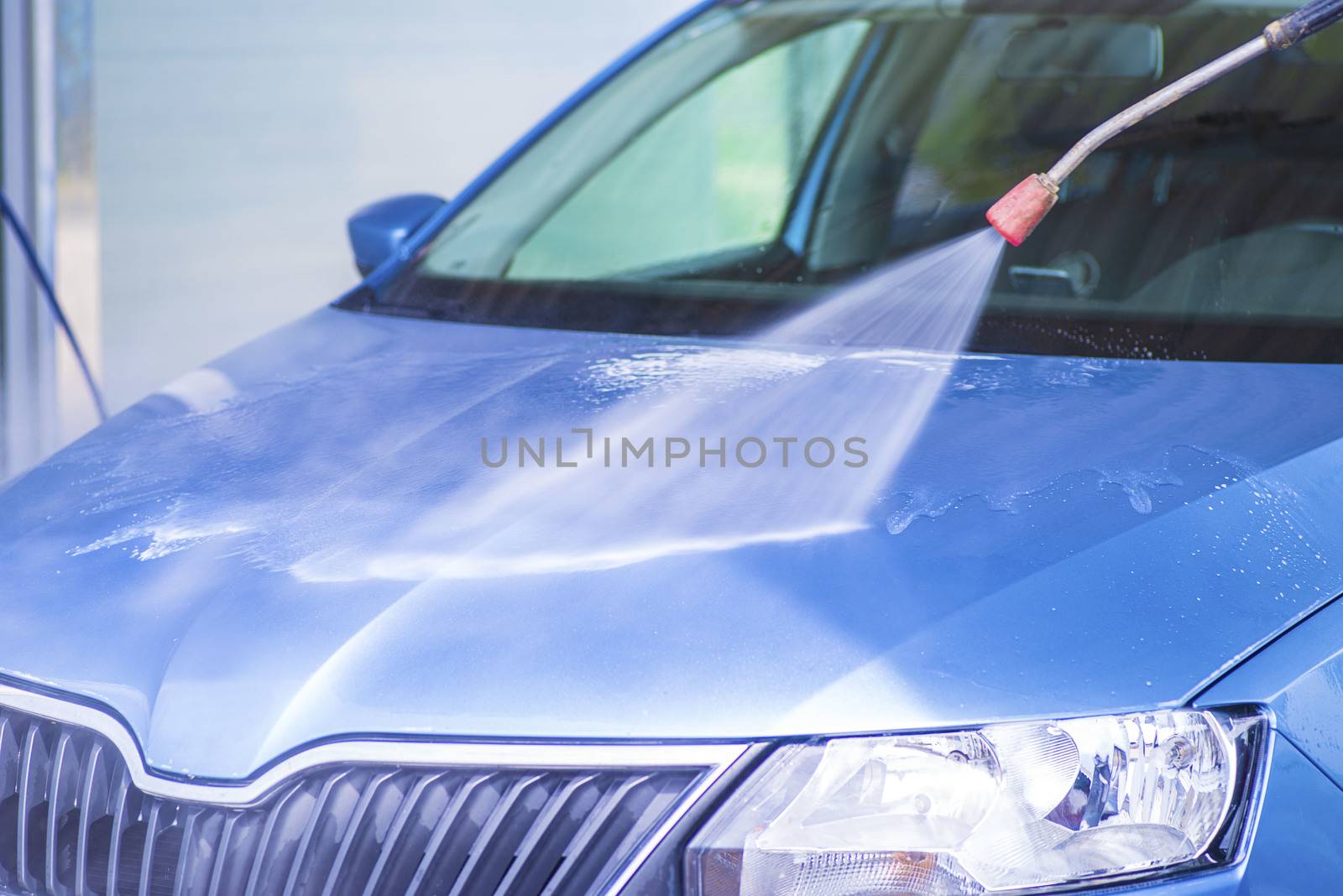 Cleaning Car Using High Pressure Water.Manual car wash with pressurized water in car wash outside.