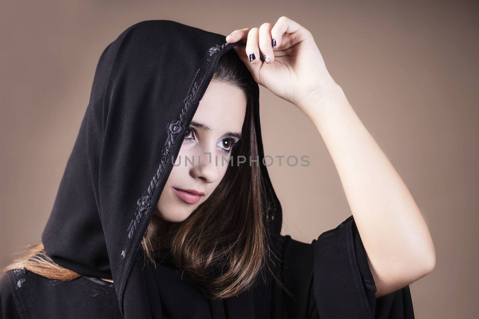 Arab saudi emirates woman face looking at side on a light background.Arab ,muslim,girl closeup on a light background.Muslim.