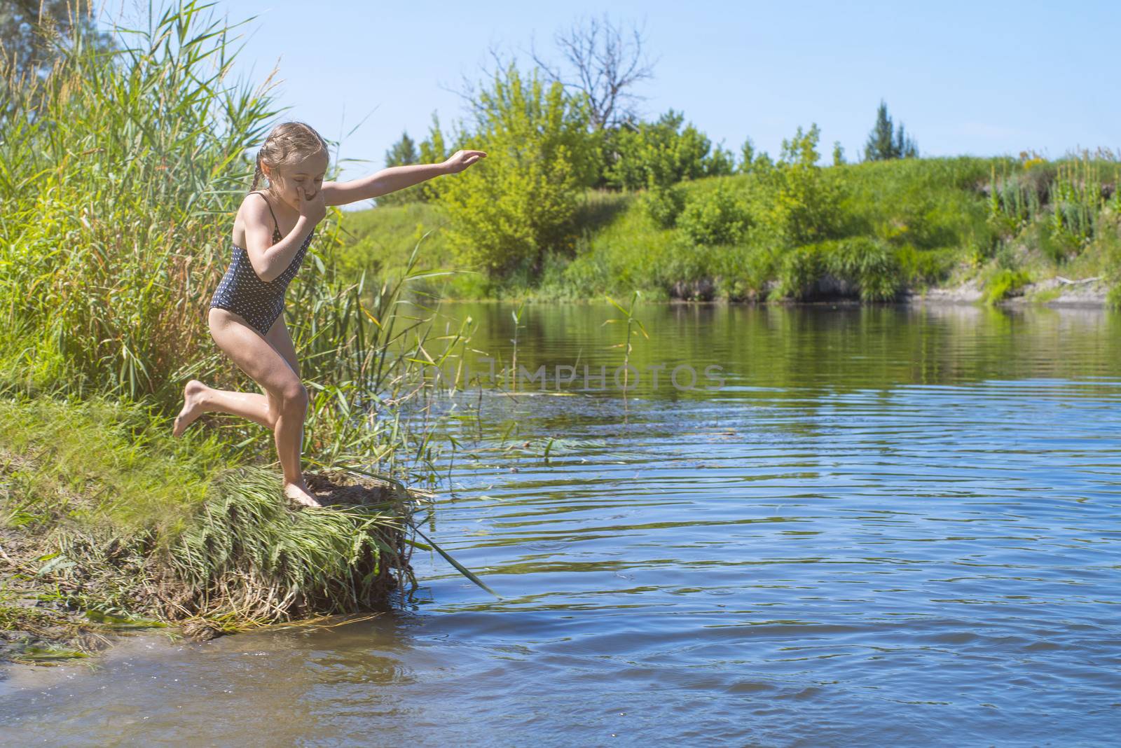 little girl running through the water with a splash . in her hands cloth.