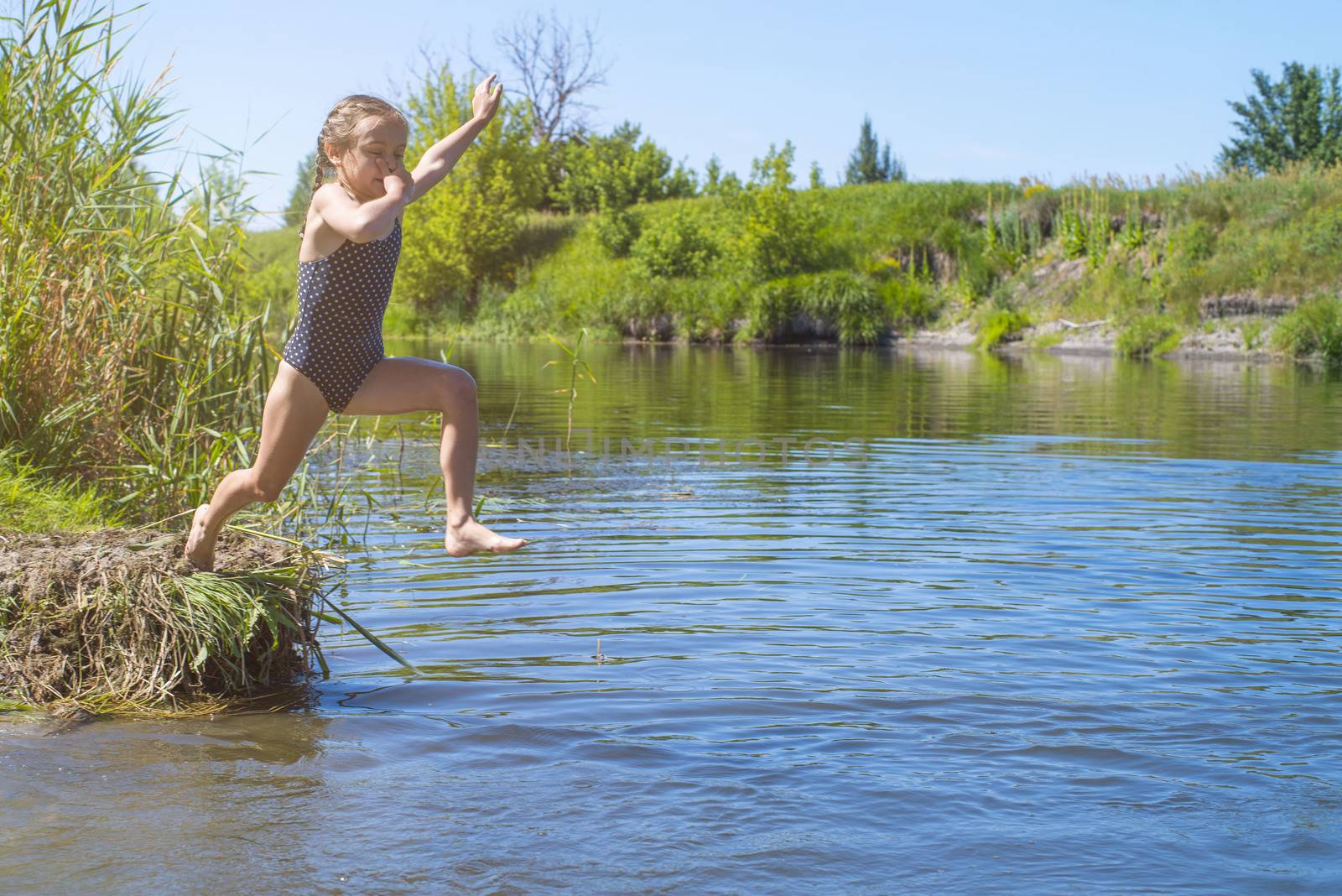 little girl running through the water with a splash . in her hands cloth.