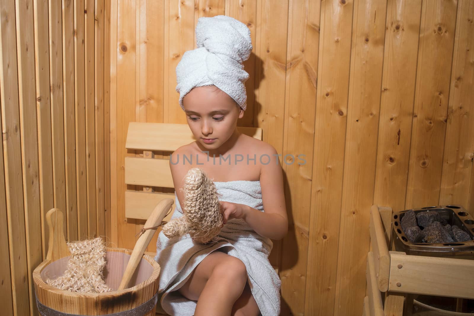 Young Girl relaxing in sauna,girl in a spa treatment in a traditional sauna with a brush for skin and a washcloth.Girl enjoying a relaxing stay in the sauna.