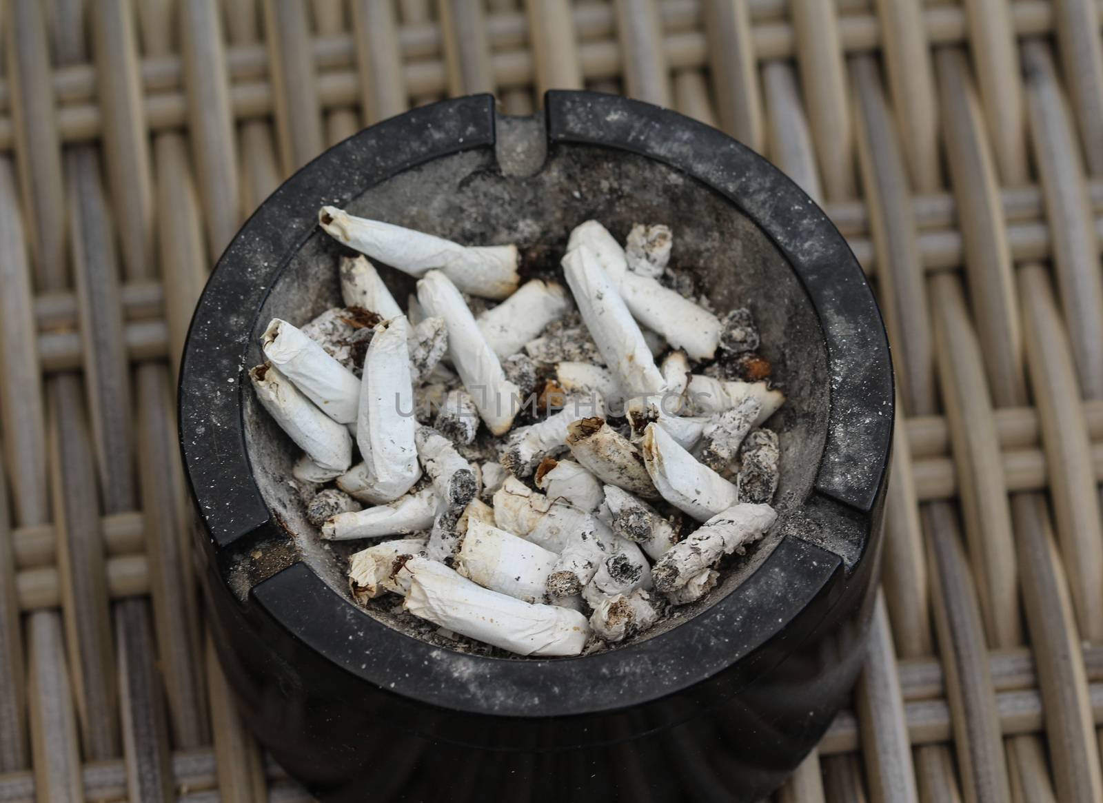 ashtray filled with tobacco ash and cigarette butts by michaelmeijer