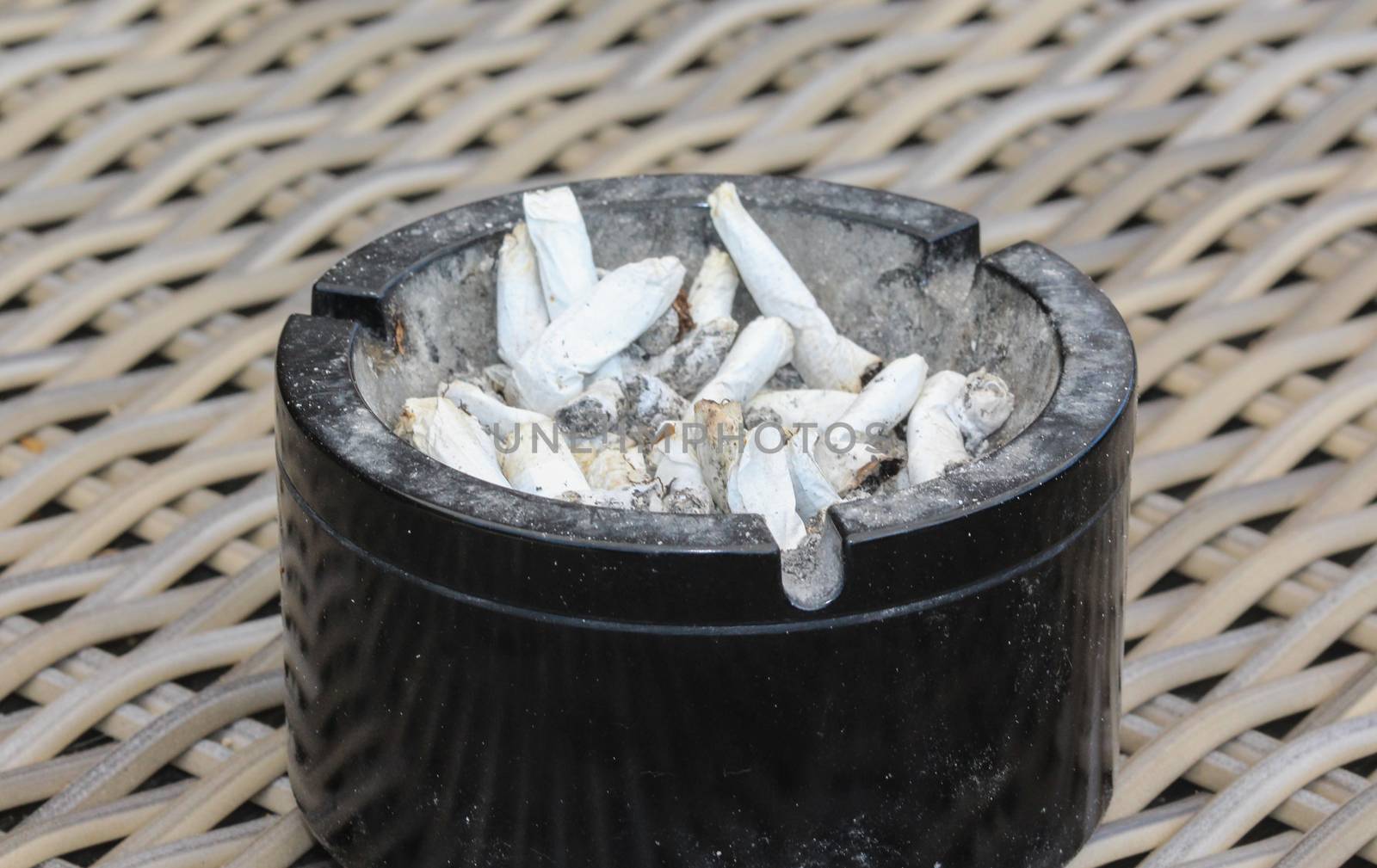 ashtray filled with tobacco ash and cigarette butts by michaelmeijer