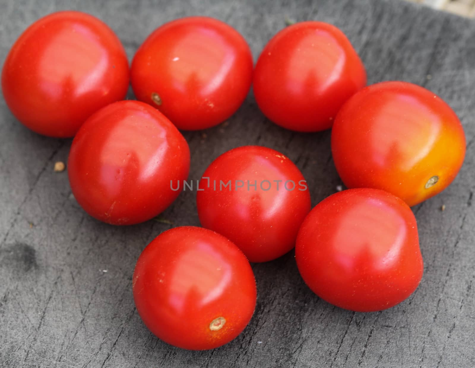 Close up of Fresh red cherry tomato on black cutting board background