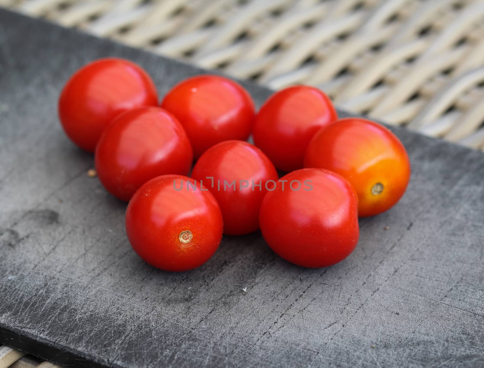 Close up of Fresh red cherry tomato on black cutting board background