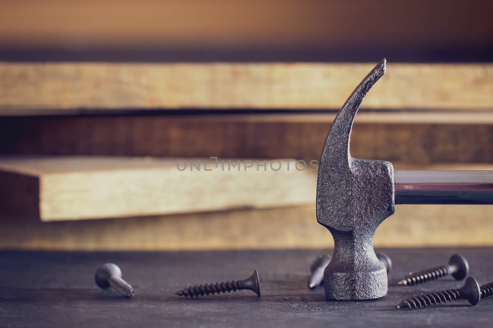 Close up hammer and screw in lumber stacking background. Copy sp by SaitanSainam