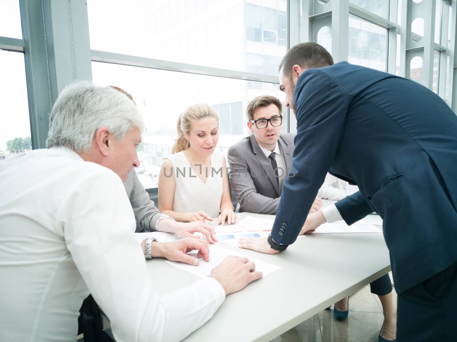 Group of business people discussing diagrams in office together