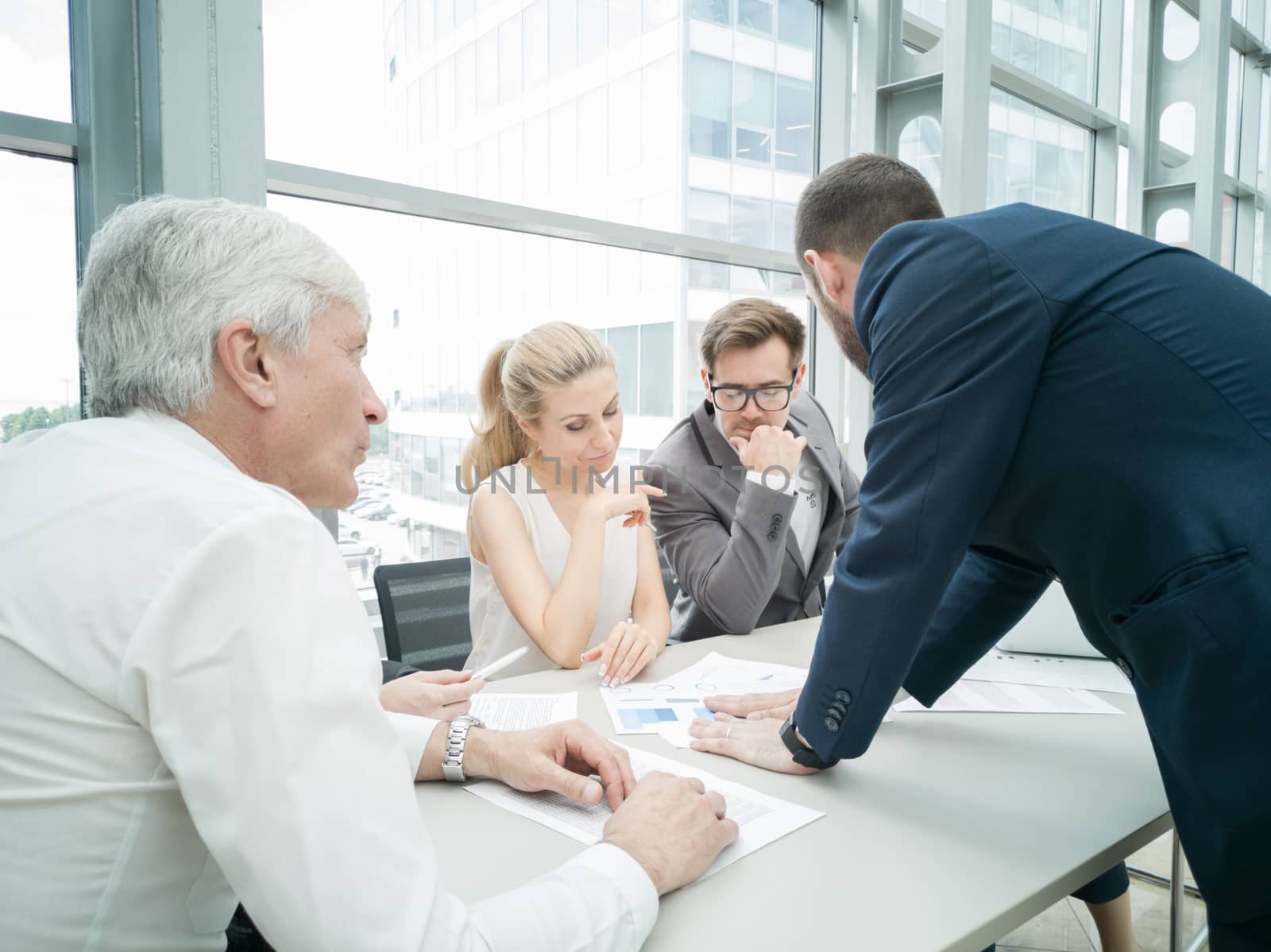 Group of business people discussing diagrams in office together