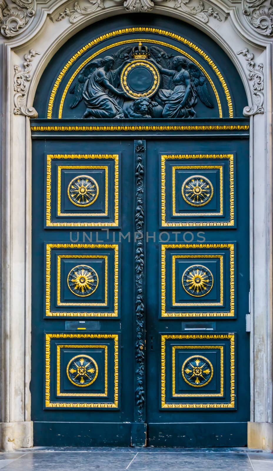Old classic doorway decorated with gold and patterns, angel statues above the door, historical architecture
