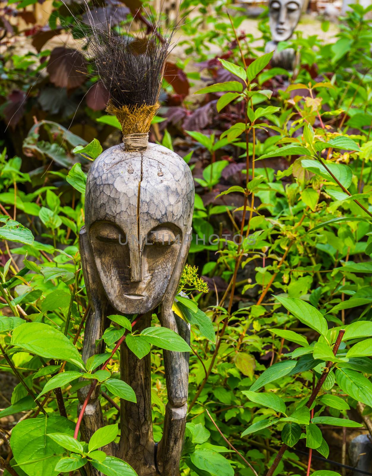 wooden aboriginal sculpture, traditional african decorations for the garden, nature background
