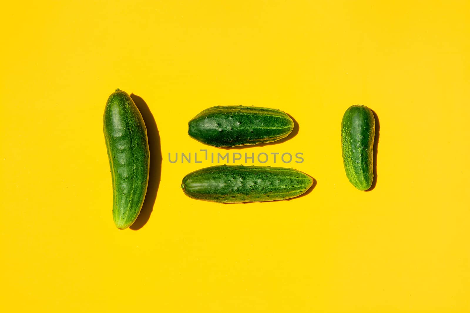 People equality concept on a yellow background. Copy space. Cucumbers for designers. Top view. by nixrenas