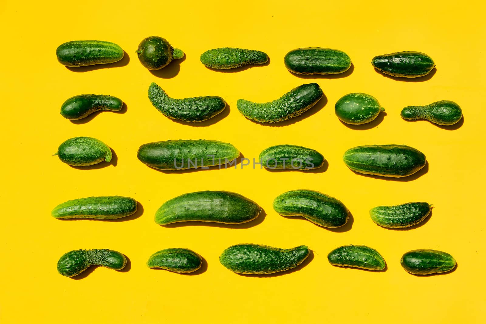 Different sizes forms cucumbers pattern on a light yellow background. Copy space. by nixrenas