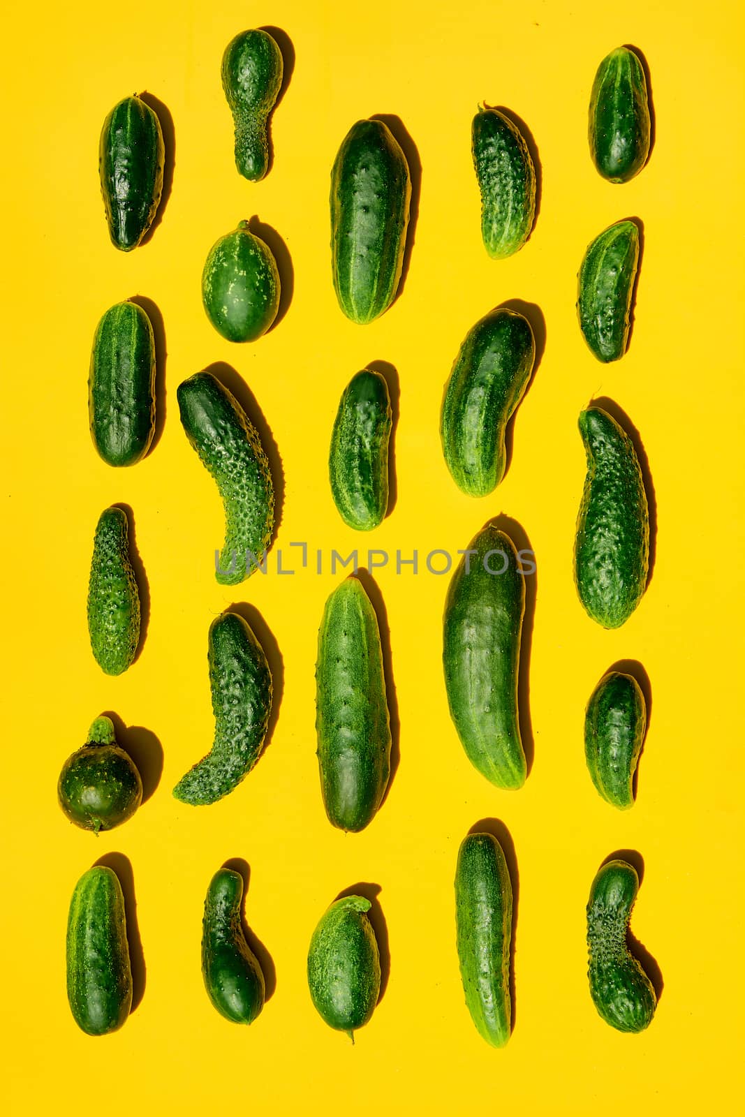 Different sizes forms cucumbers pattern on a light yellow background. Copy space. by nixrenas