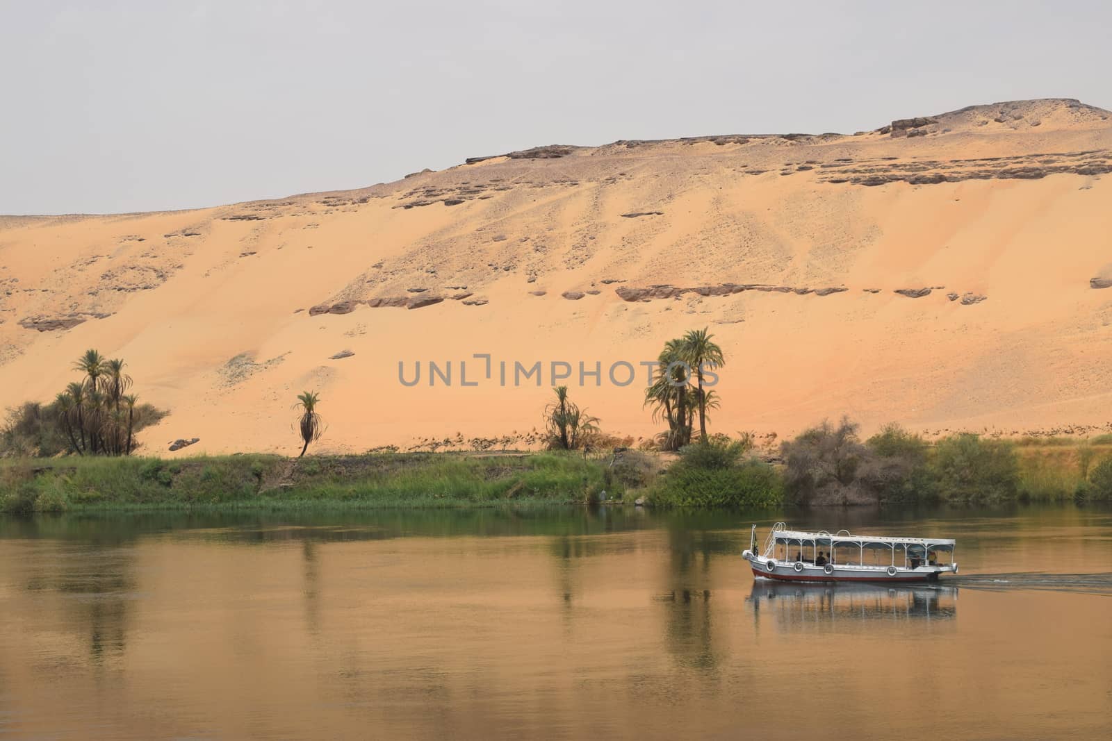 The beginning of the Sahara Desert With the Nile in the foreground taken in Aswan Egypt with Nile River Boat