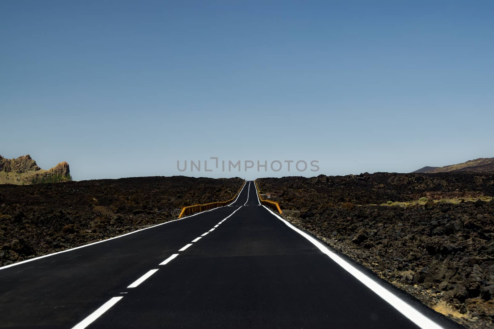 Long Empty Road Though Volcanic Rocks on An Island in Spain