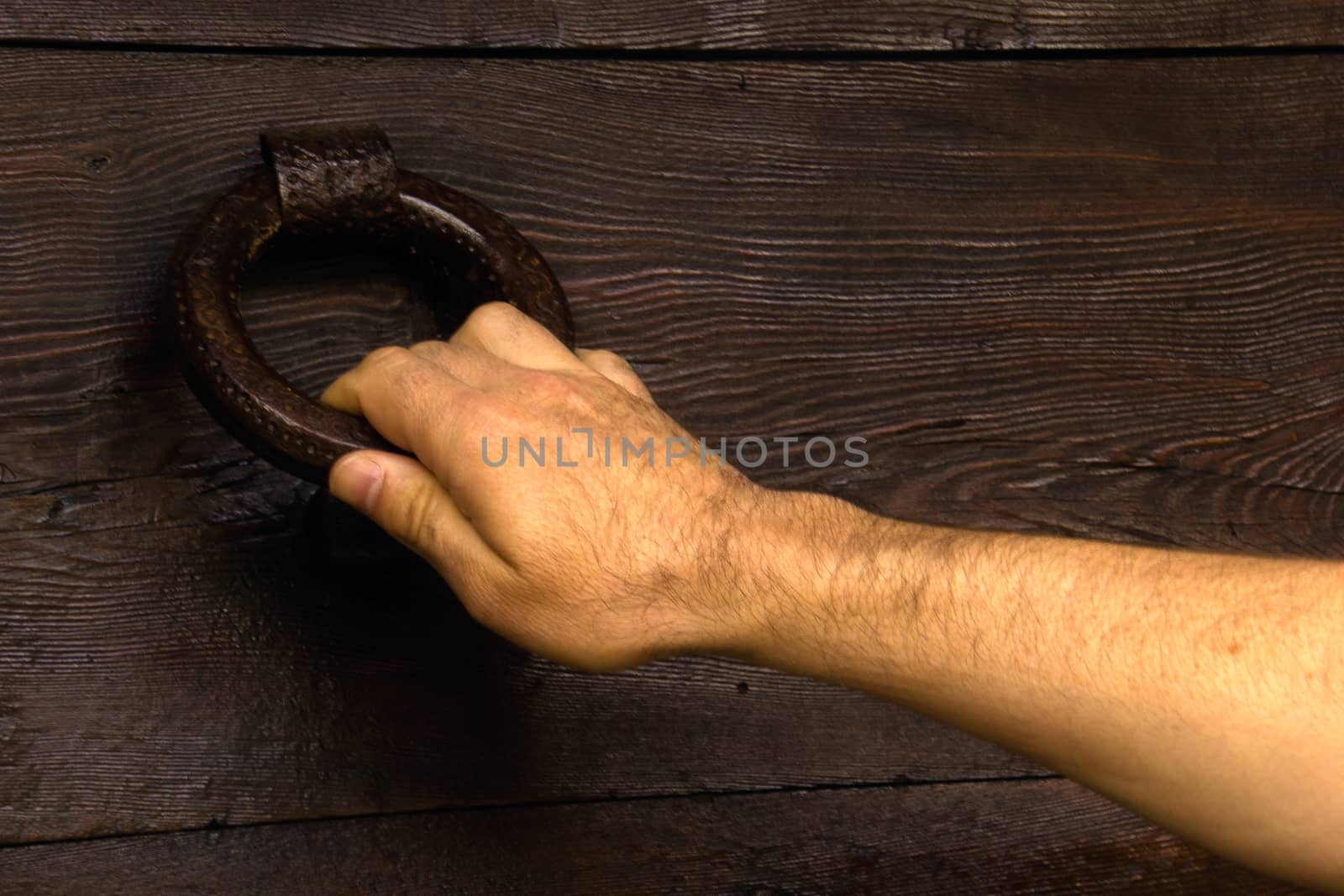 hand of a man knocking at the door by Joanastockfoto