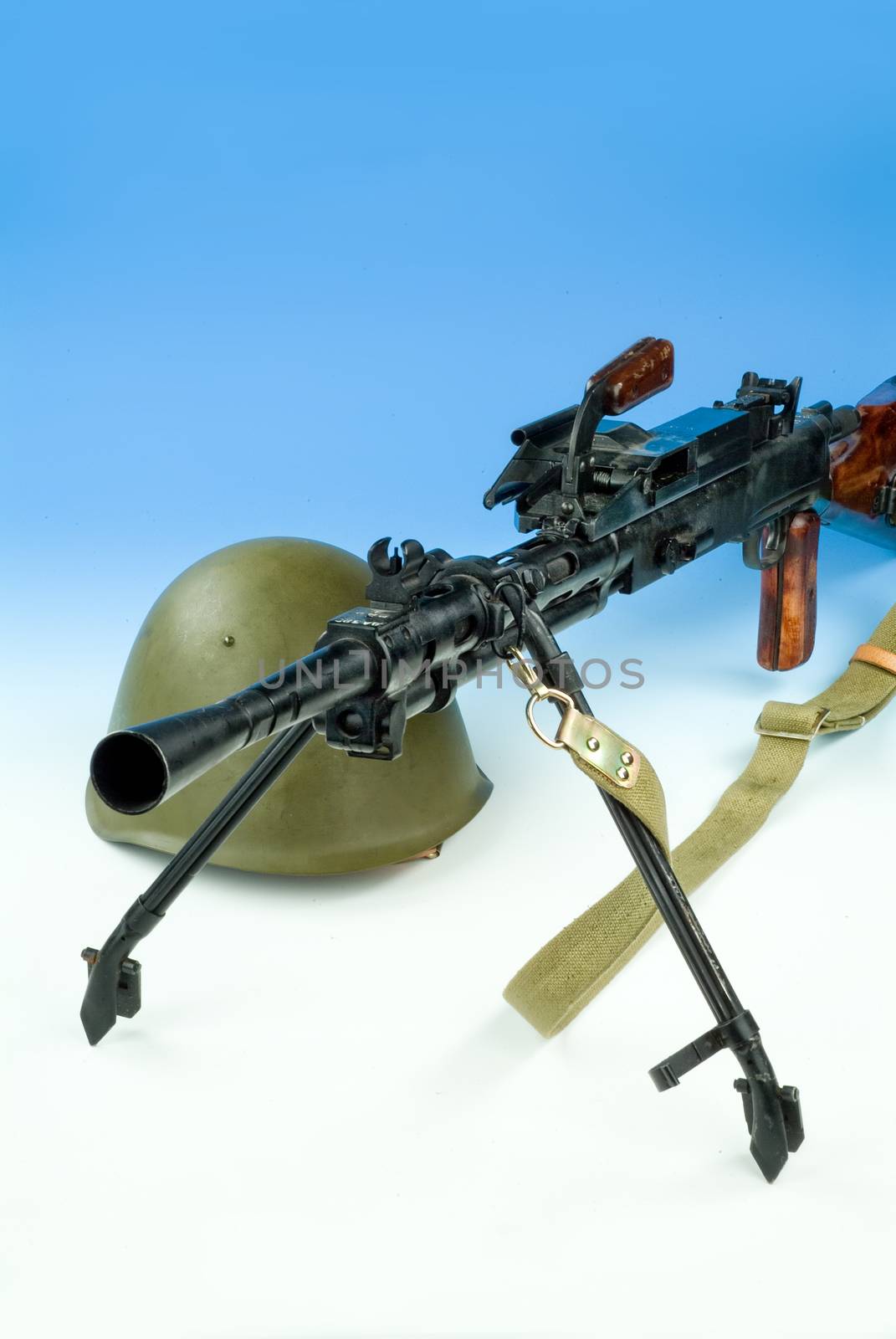 Machine gun and flowers in an army helmet