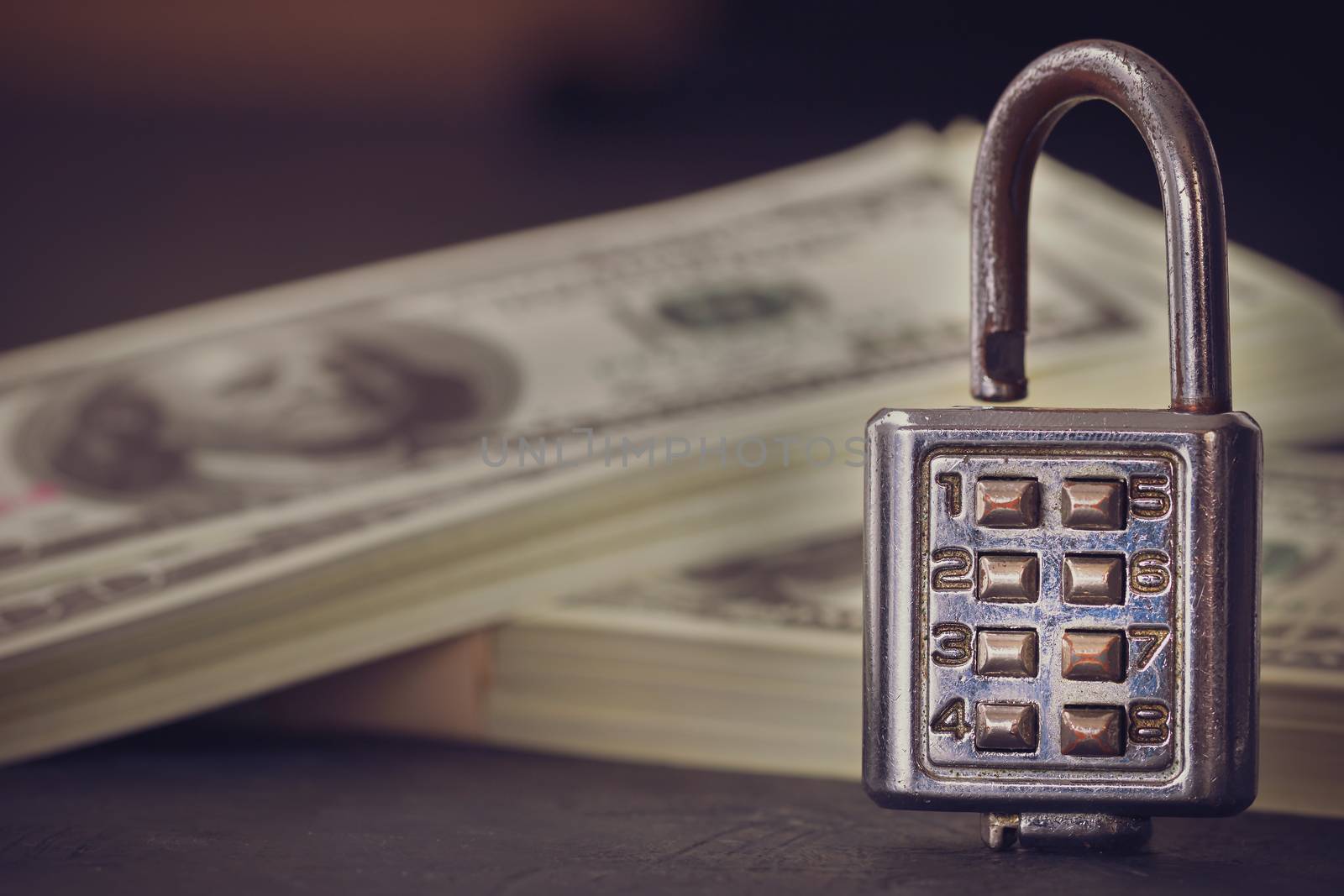 Combination padlock and dollar banknote in darkness. Concept of business secrets or financial security.