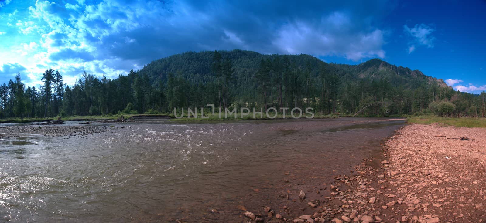 Panoramic picture of the Ursul River flowing at the foot of the mountain ranges. Altai, Siberia, Russia.