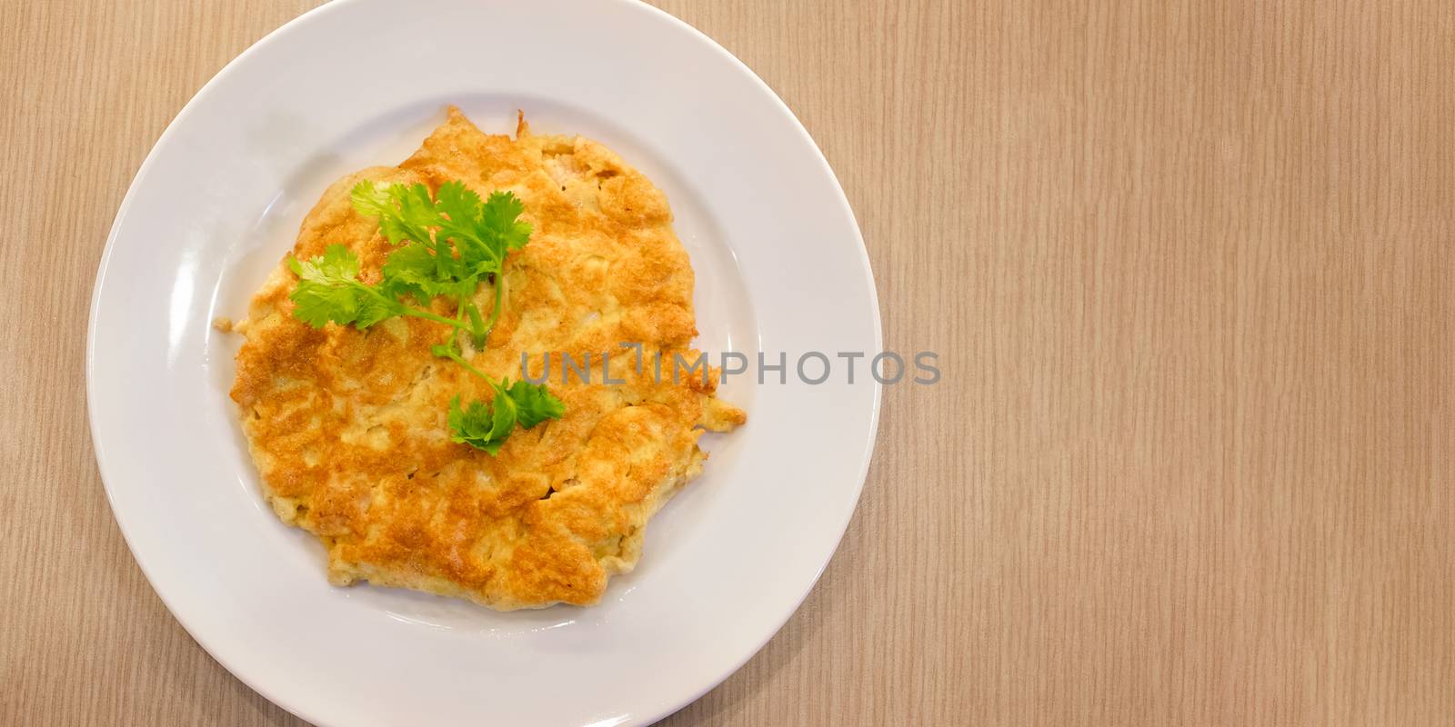 Freshly Cooked Omelette with topped with Corriander on a Round Dish. by seika_chujo