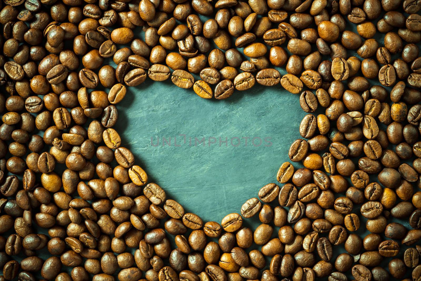 Coffee bean in heart shape on wooden table. Concept i love coffe by SaitanSainam