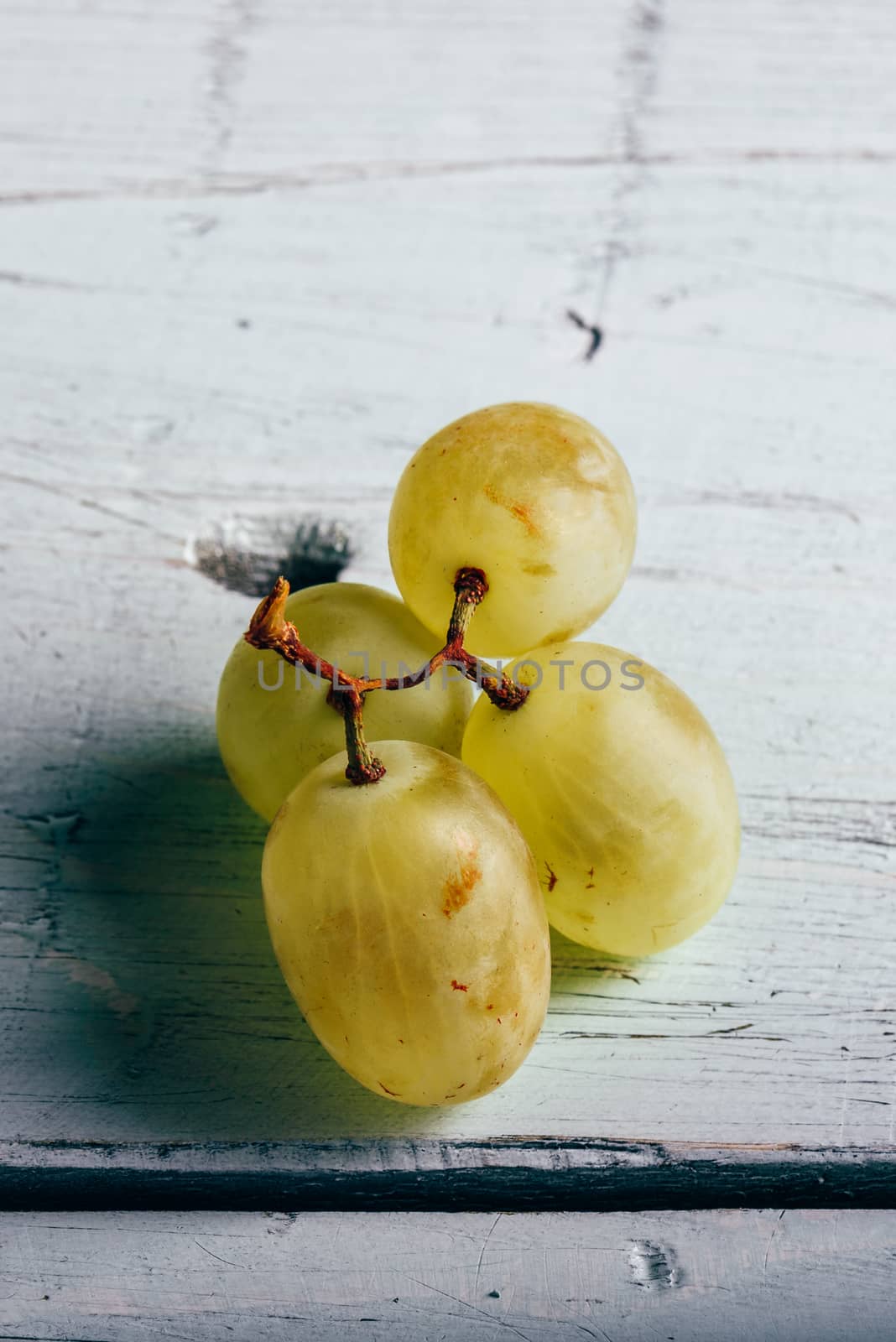 Ripe green grapes on wooden background. by Seva_blsv