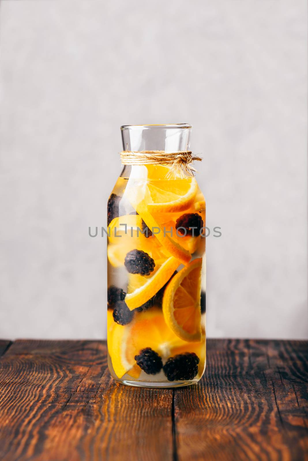 Bottle of Detox Water Infused with Sliced Raw Orange and Fresh Blackberry.