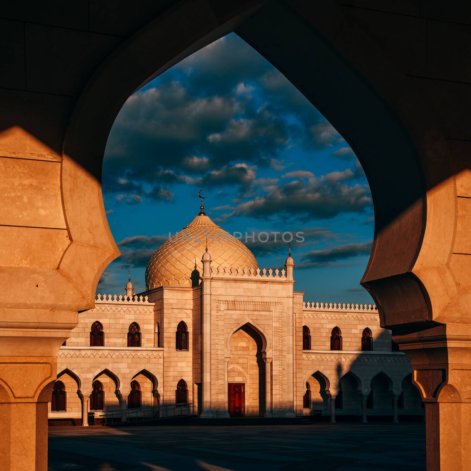 Beautiful White Mosque in the Sunset Light. View through the Arch.