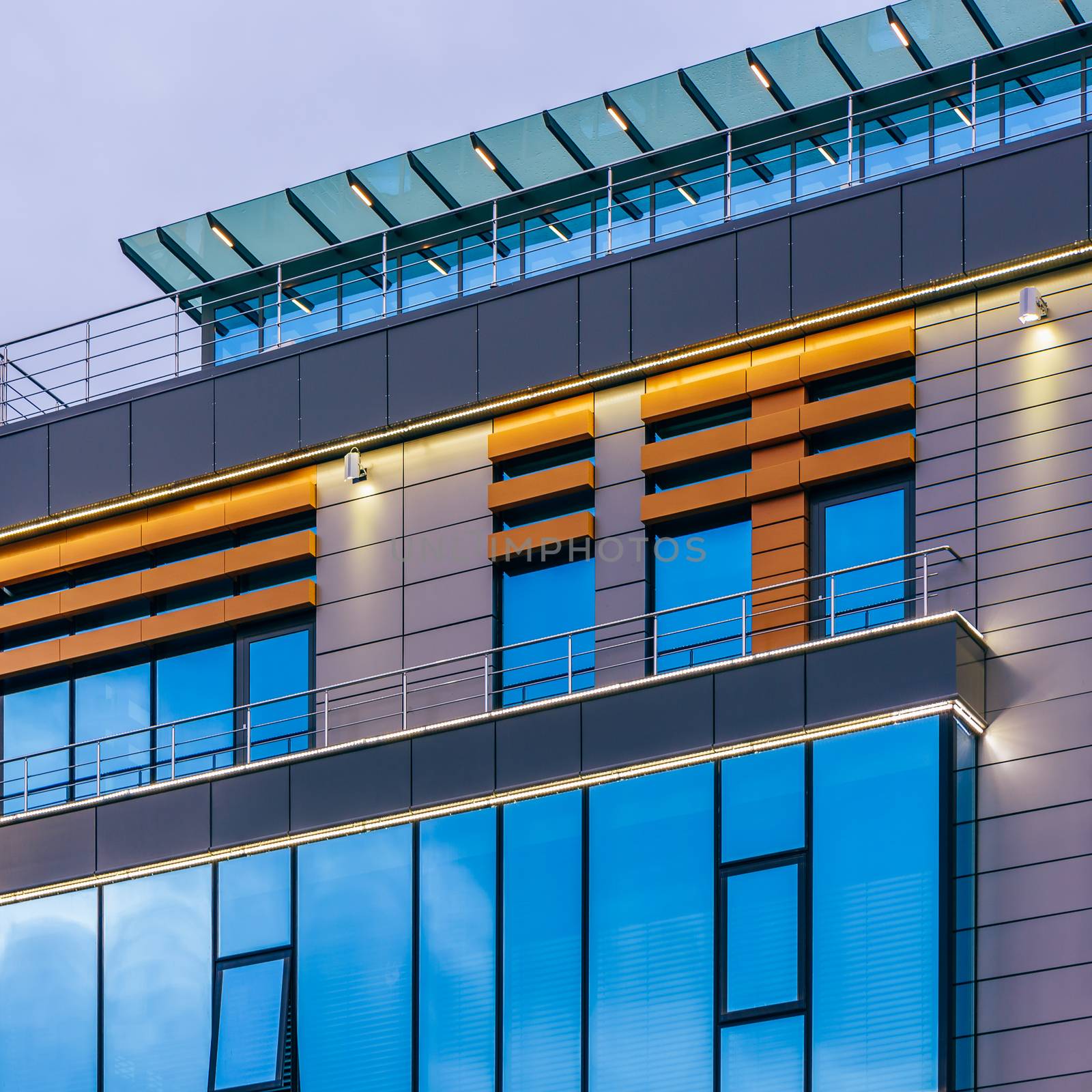 Modern high-rise office building with a glass facade at overcast, background.