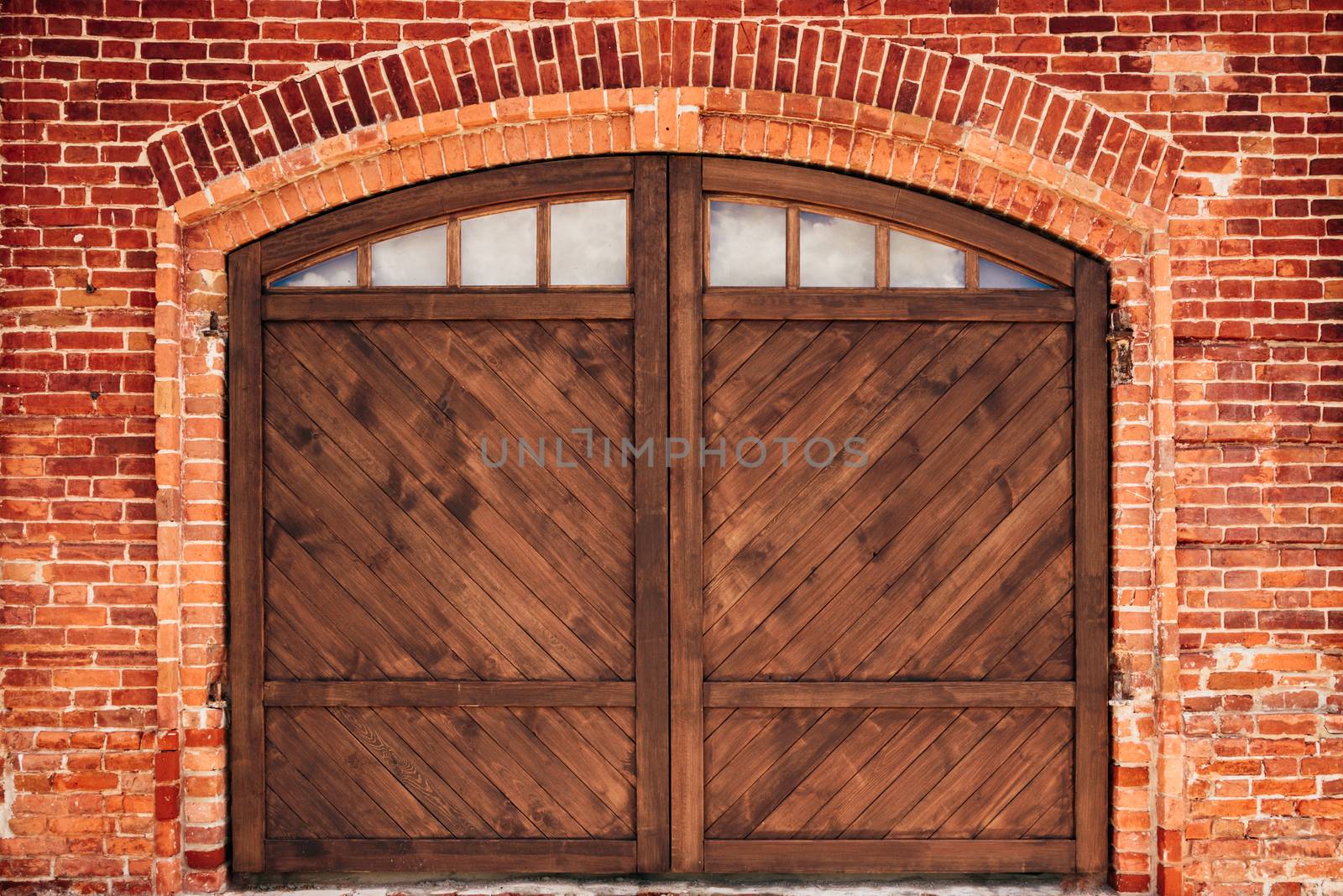 Old Brick Wall with Arch and Wooden Door.