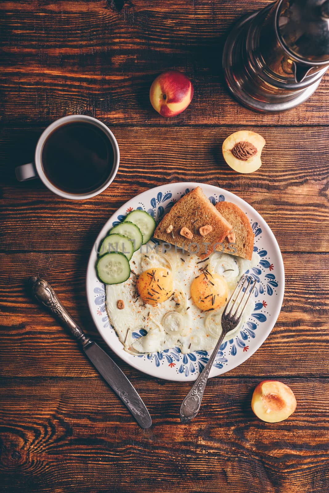 Breakfast toast with fried eggs with vegetables on plate and cup of coffee with fruits over dark wooden background, top view. Clean eating concept.
