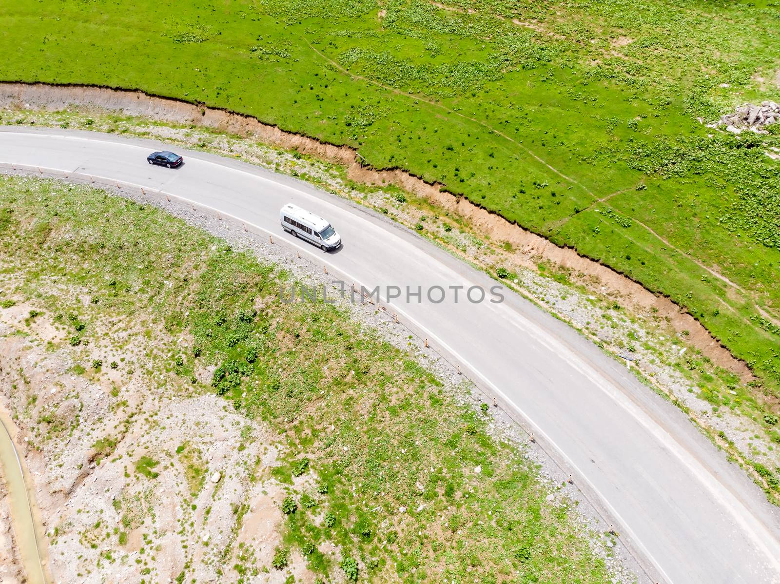 Top view of the road serpentine in the mountains, on the road cars